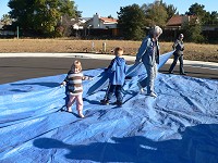 Both kids helping to pack the tarp