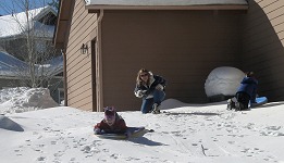 Kids riding a sleigh in Táňa's back yard