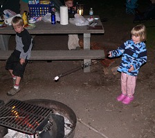 Filip assists Lisa in roasting marshmallows